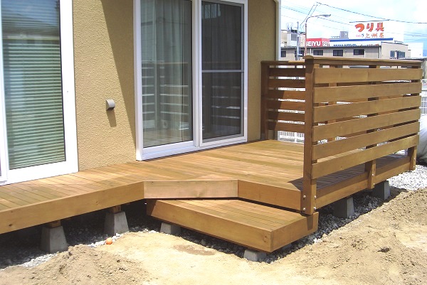 茶色い塗り壁のお宅にマッチした、ウッドフェンス＆ウッドデッキ。