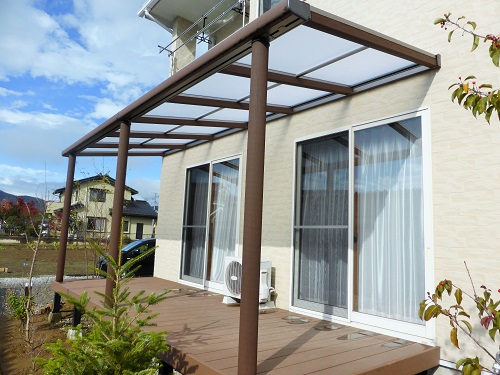 木調のテラス屋根とアートウォールの門柱。