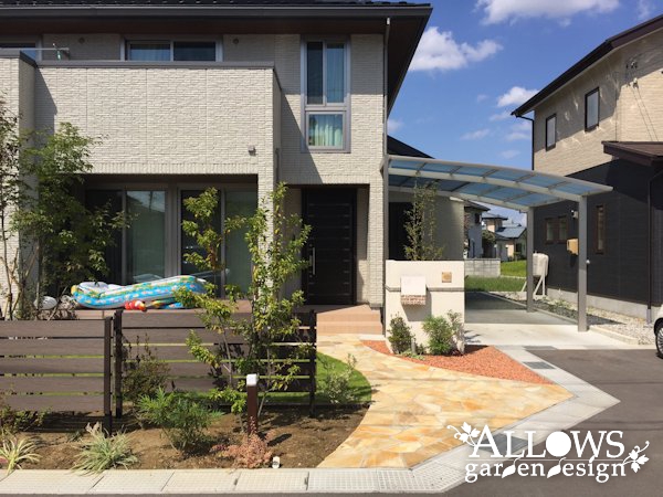 木調フェンスと高木で仕切った庭