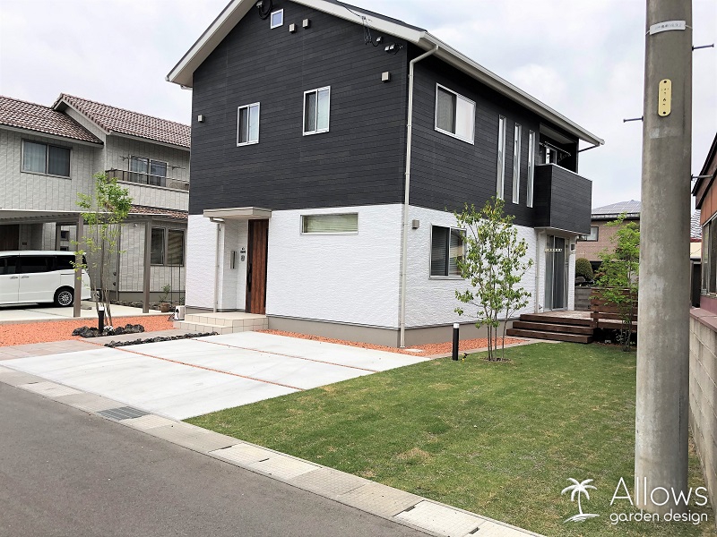 シンプルな駐車スペースとナチュラルな庭空間