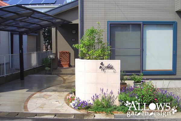 高級感のある砂岩調の門柱と曲線アプローチ